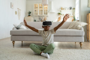 Overjoyed little African American boy wearing vr headset spending leisure time in virtual reality